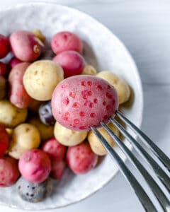 close up of raw Roasted Rosemary Potatoes in a white bowl