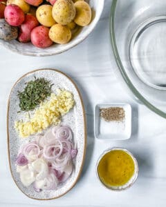 ingredients for Roasted Rosemary Potatoes measured out against a white surface