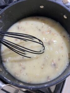 process of mushroom gravy ingredients being mixed in a pan