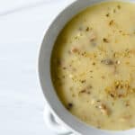 completed close up bowl of mushroom gravy against a white background