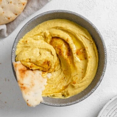 completed Curried White Bean Dip in a gray. bowl against a white background