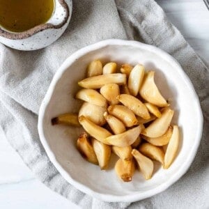 completed Stovetop Roasted Garlic in a white bowl against a white background