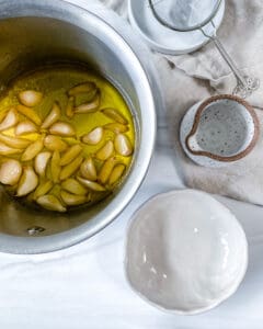 process of making Stovetop Roasted Garlic with cloves of garlic in bowl of oil