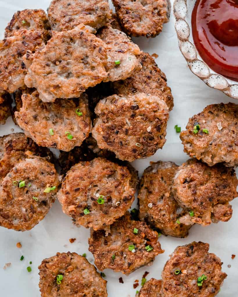 completed Quinoa Tater Tots on a white surface with a fork and sauce on the side