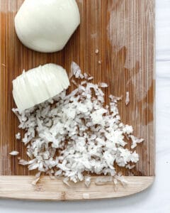 cut up onion on a brown cutting board