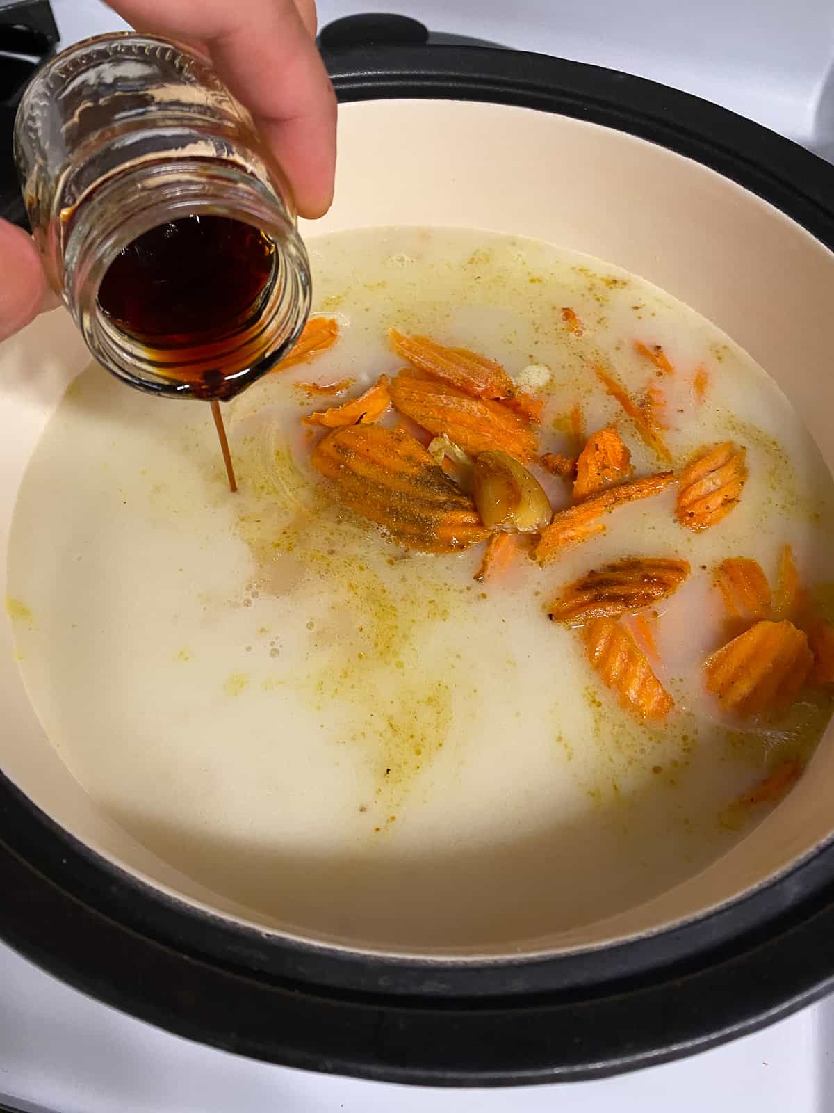 process shot of adding soy sauce to pan