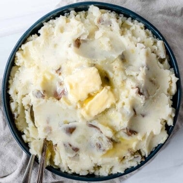 completed vegan mashed potatoes plated against white surface