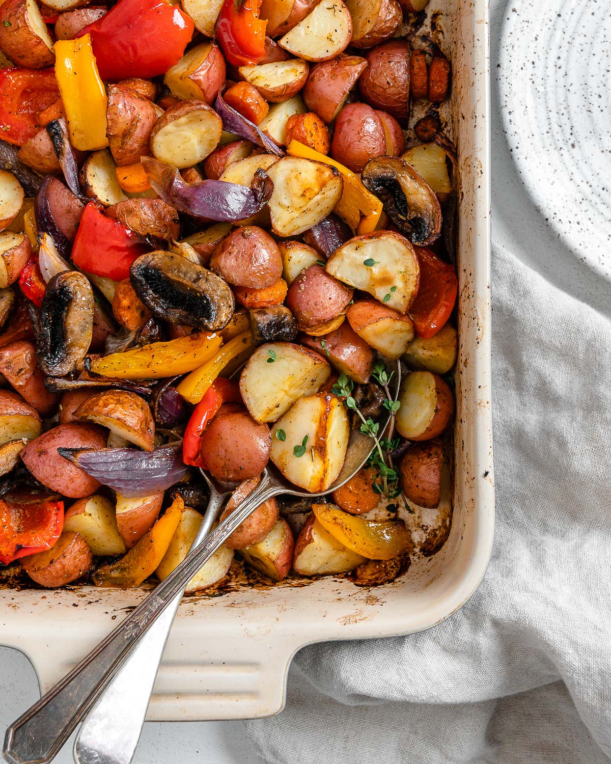 completed Vegan Roasted Vegetables with Thyme in a baking dish against a white background