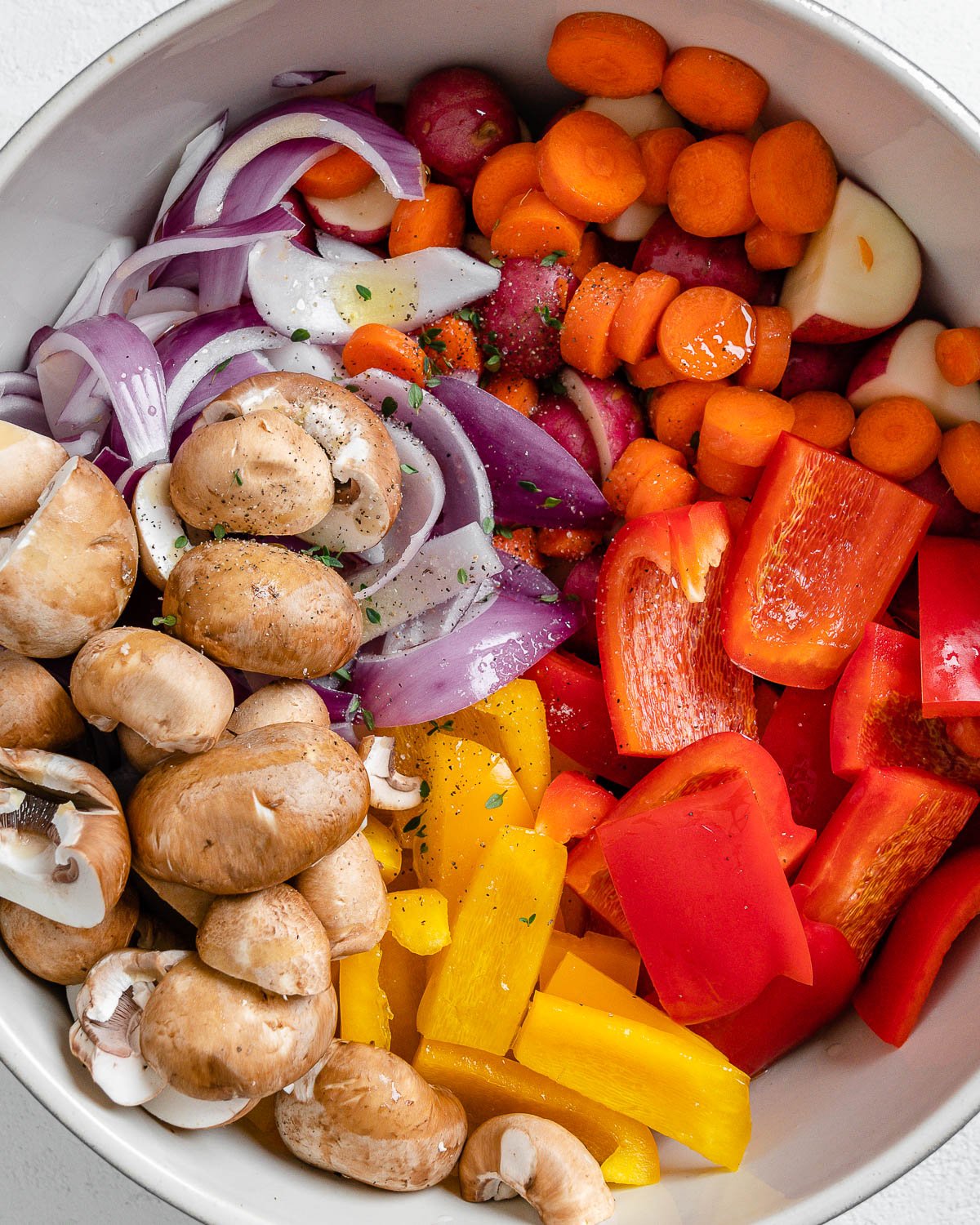 process of adding spices to bowl of veggies