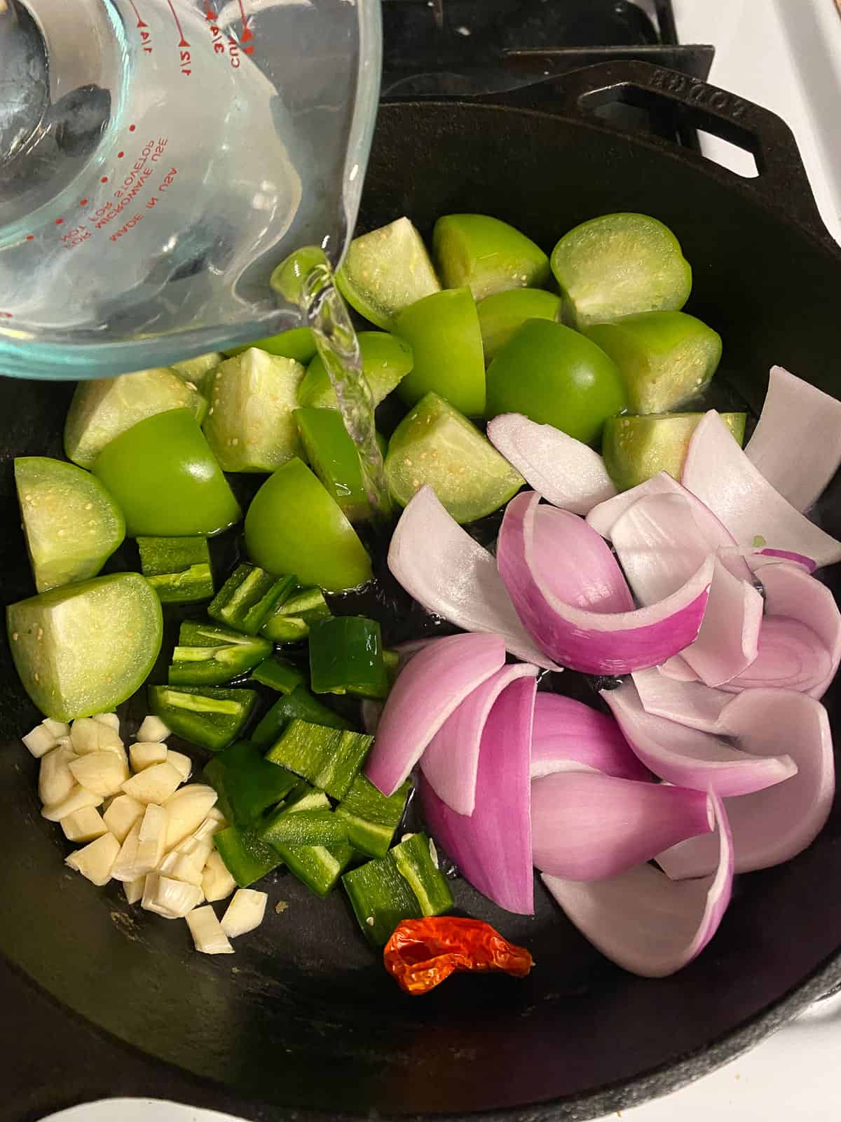 process of adding water to pan of veggies