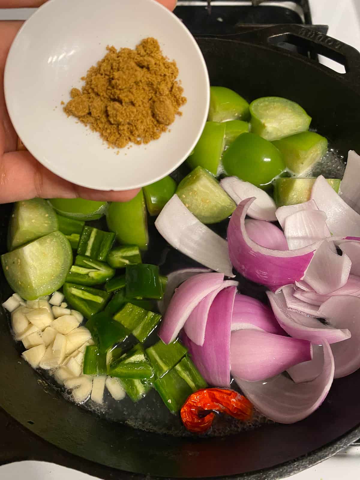 process of adding seasoning to pan of veggies