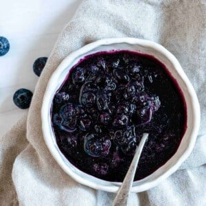 completed 2 Minute Blueberry Maple Syrup in a white bowl against a white surface and light towel