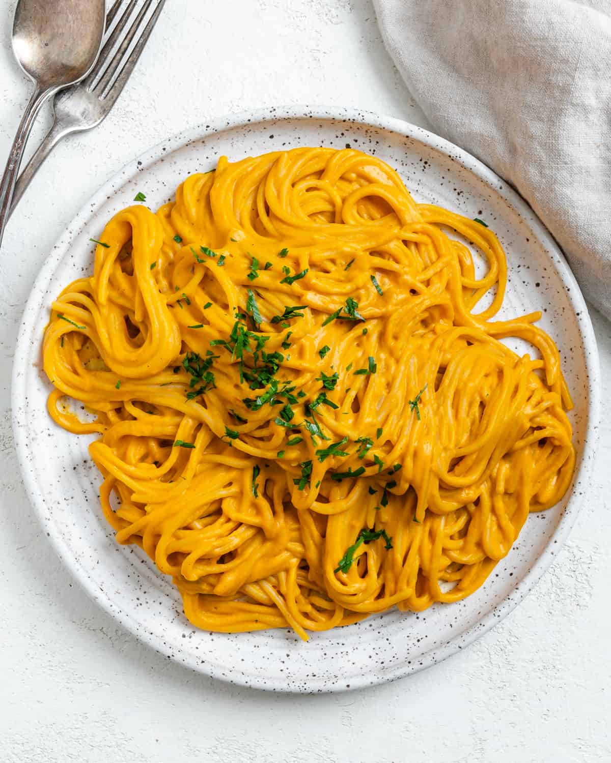 completed Sweet Potato Pasta Sauce with Spaghetti plated against a white surface