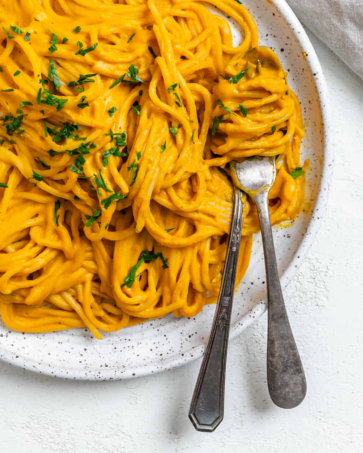 completed Sweet Potato Pasta Sauce with Spaghetti plated against a white surface