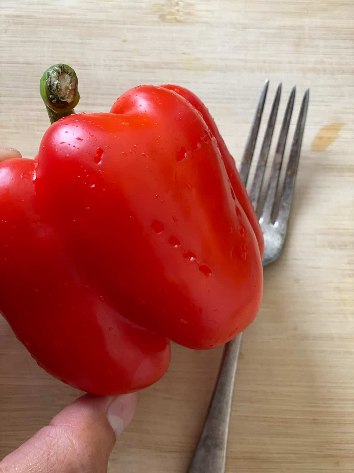 close up of red pepper with poked holesagainst a light background