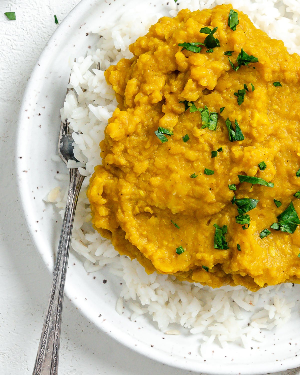 completed Easy Yellow Dal on rice in a white plate against a light background