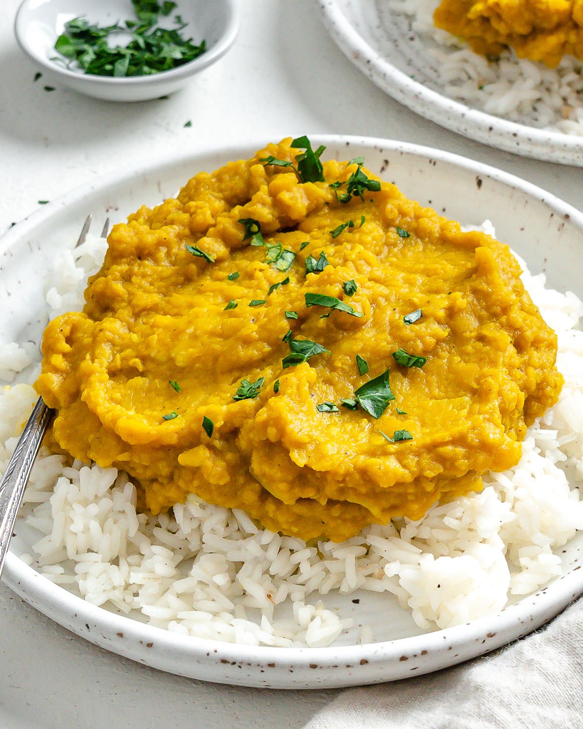 completed Easy Yellow Dal on rice in a white plate against a light background