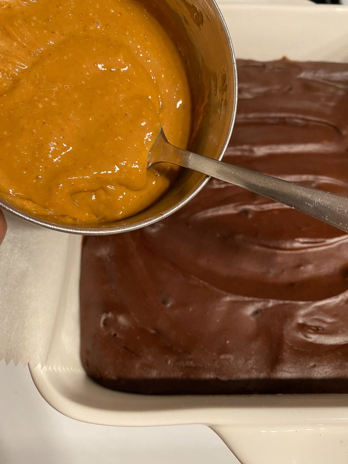 process of adding peanut butter mixture to top of brownie mixture