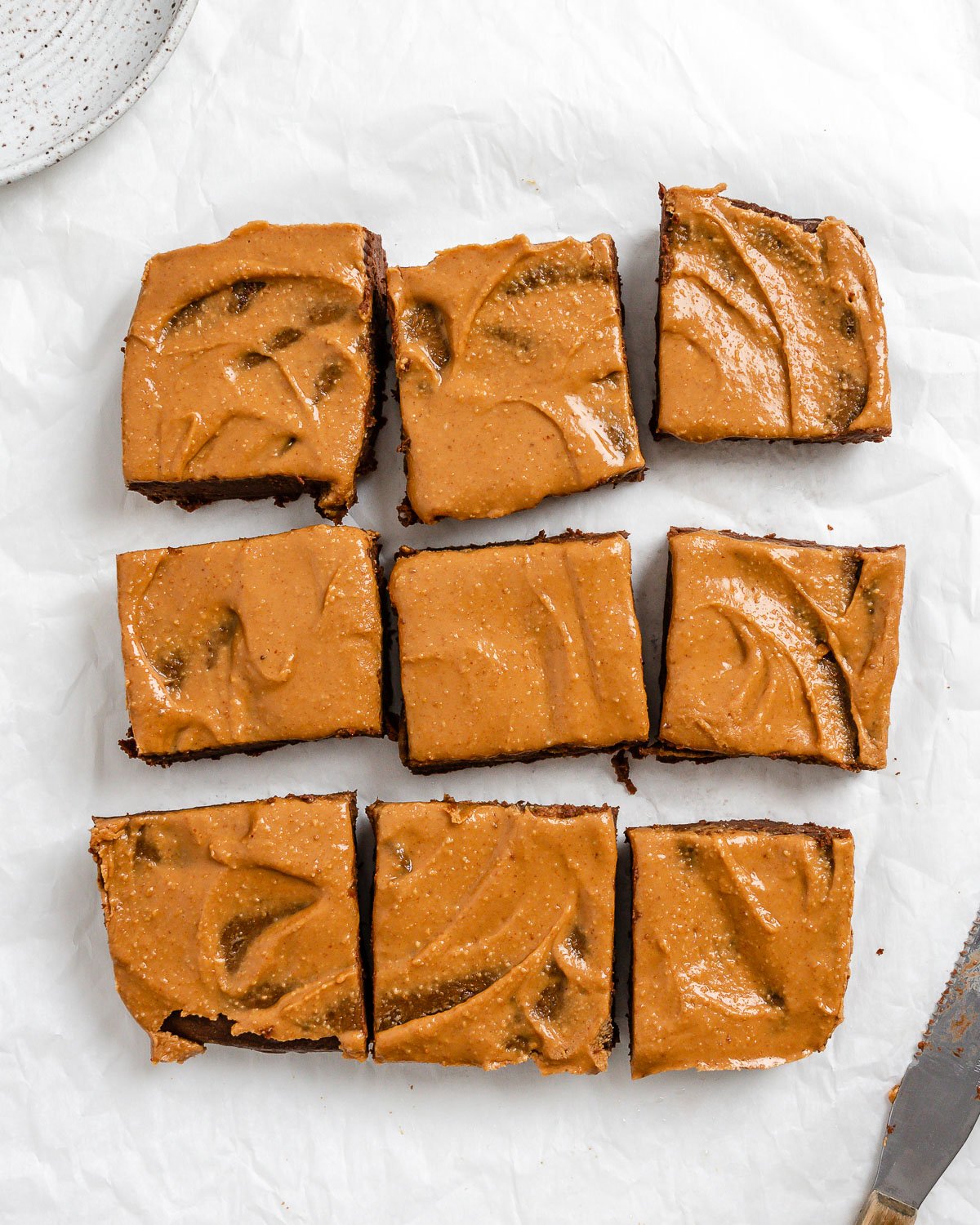 completed Sweet Potato Brownies cut into 9 squares on a white surface