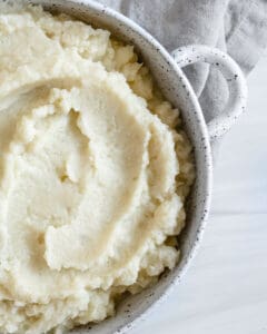 completed mashed cauliflower in a white dish against white background