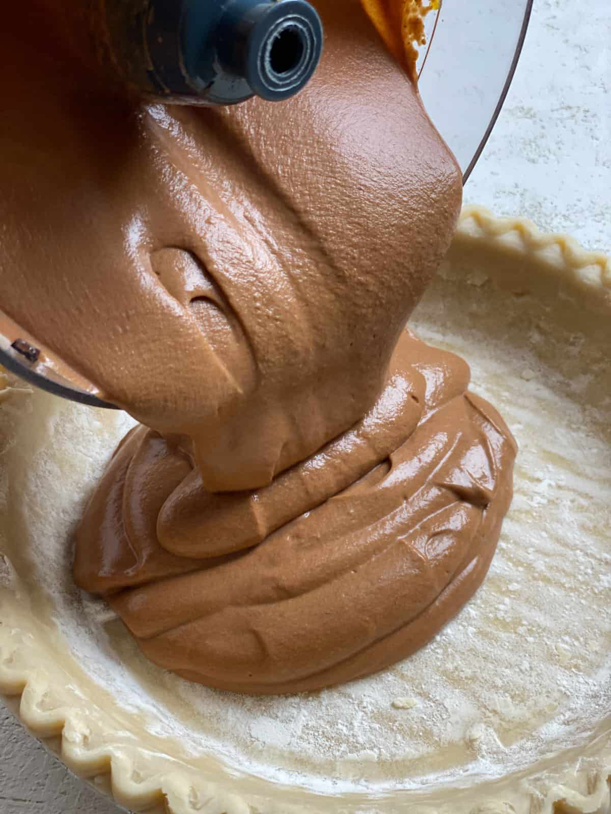 process shot of adding filing for Chocolate Pumpkin Pie into pie crust