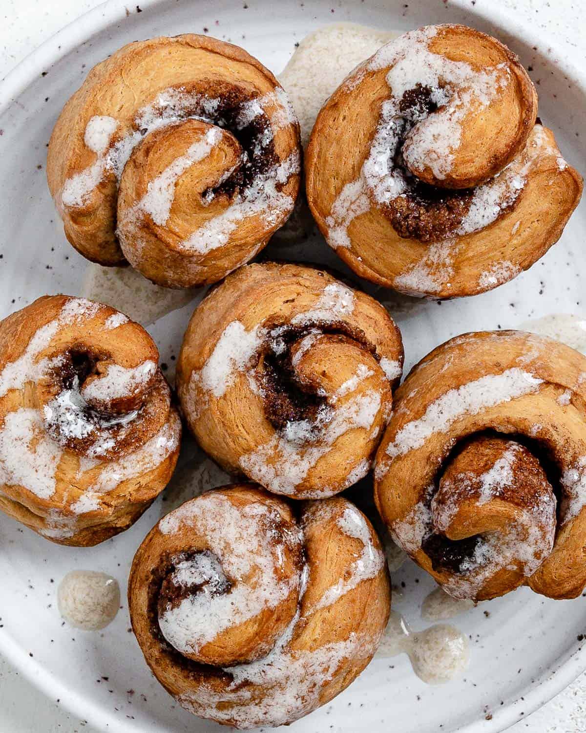 completed Cinnamon Rolls plated against a white surface