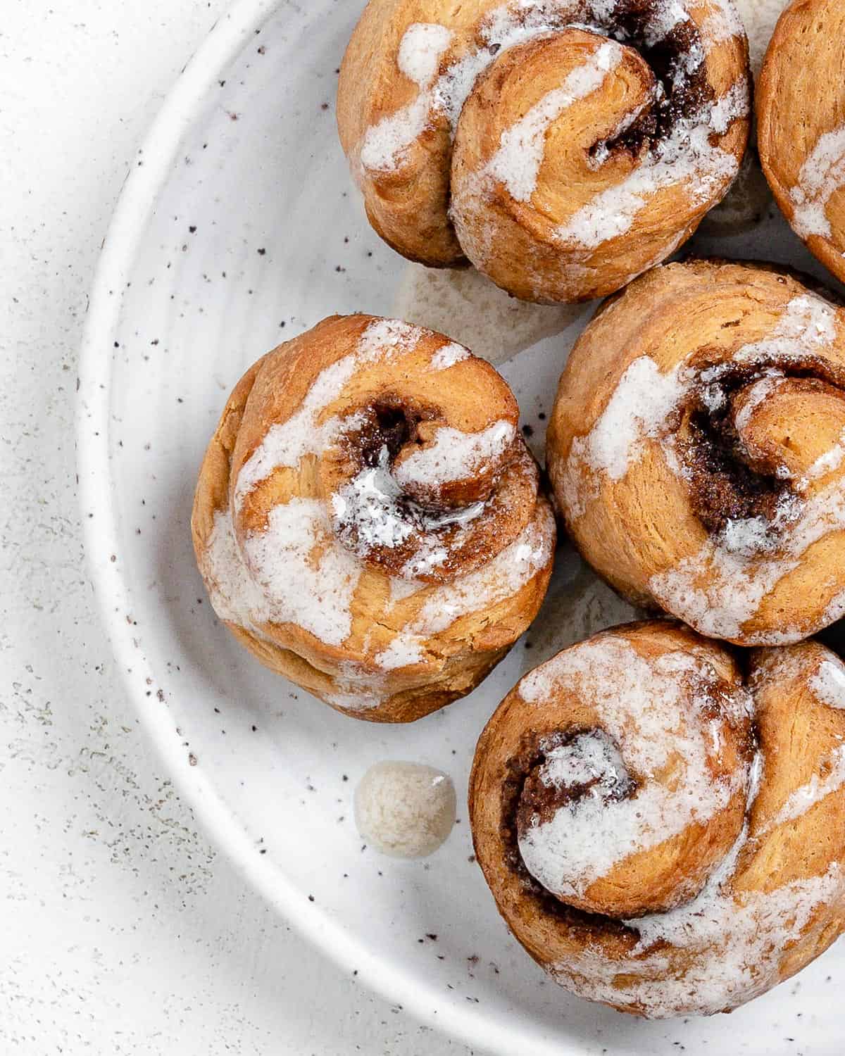 completed Cinnamon Rolls plated against a white surface