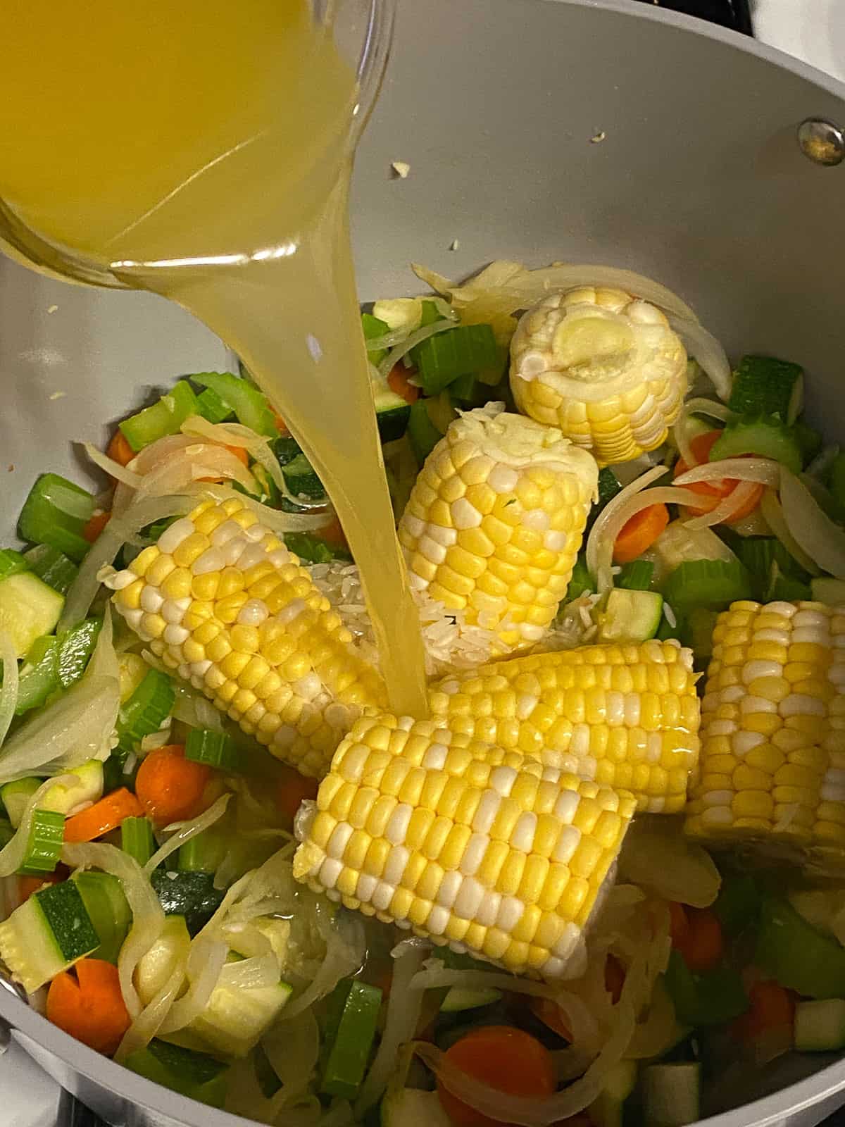 process shot of adding veggie broth to pan