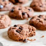 finished Chocolate Peppermint Chocolate Chip Cookies on parchment paper with one halved in the front