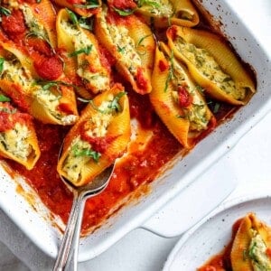 completed Stuffed Shells in a white baking dish against a white background