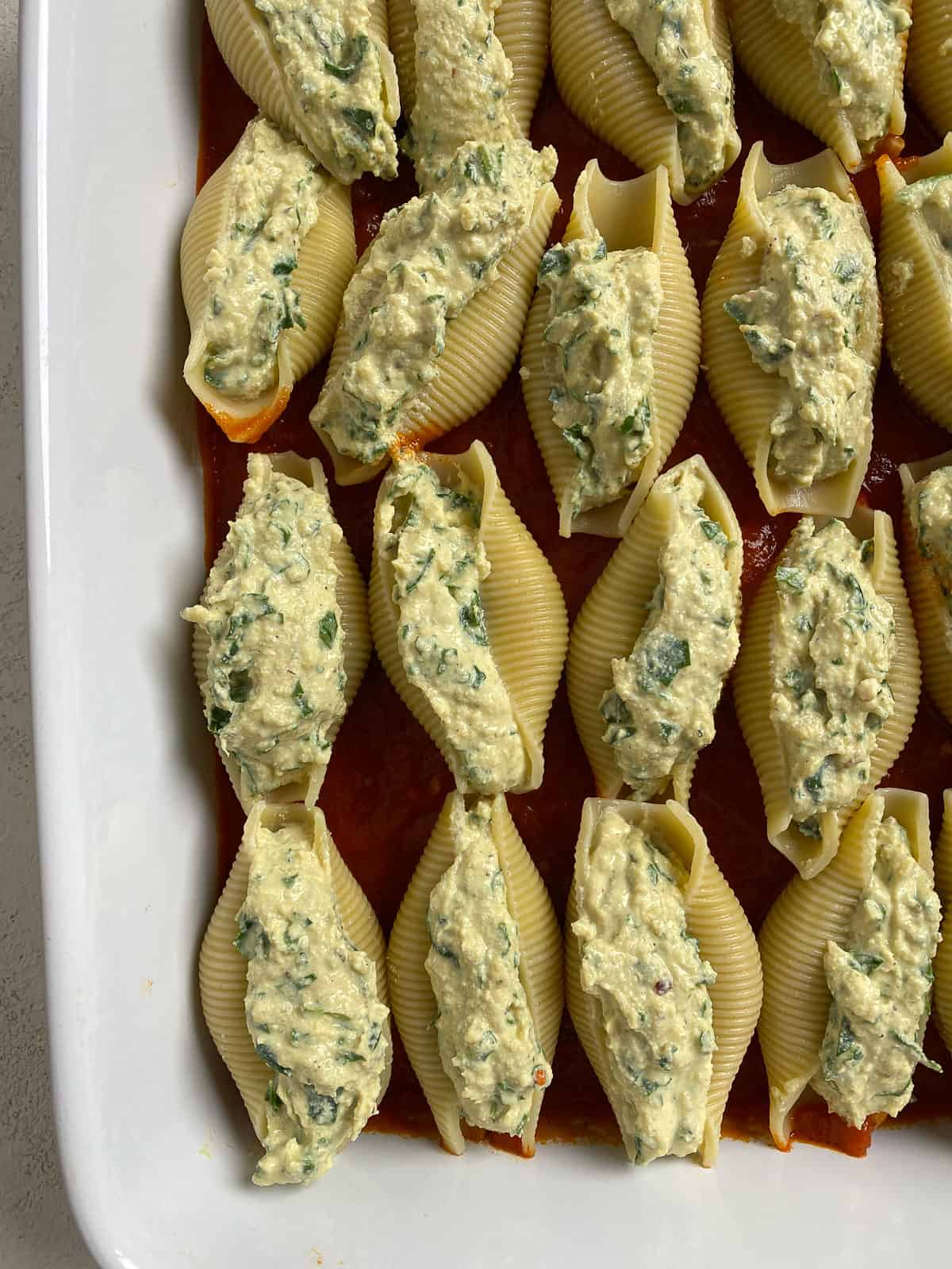 pre-baked stuffed shells aligned in baking tray