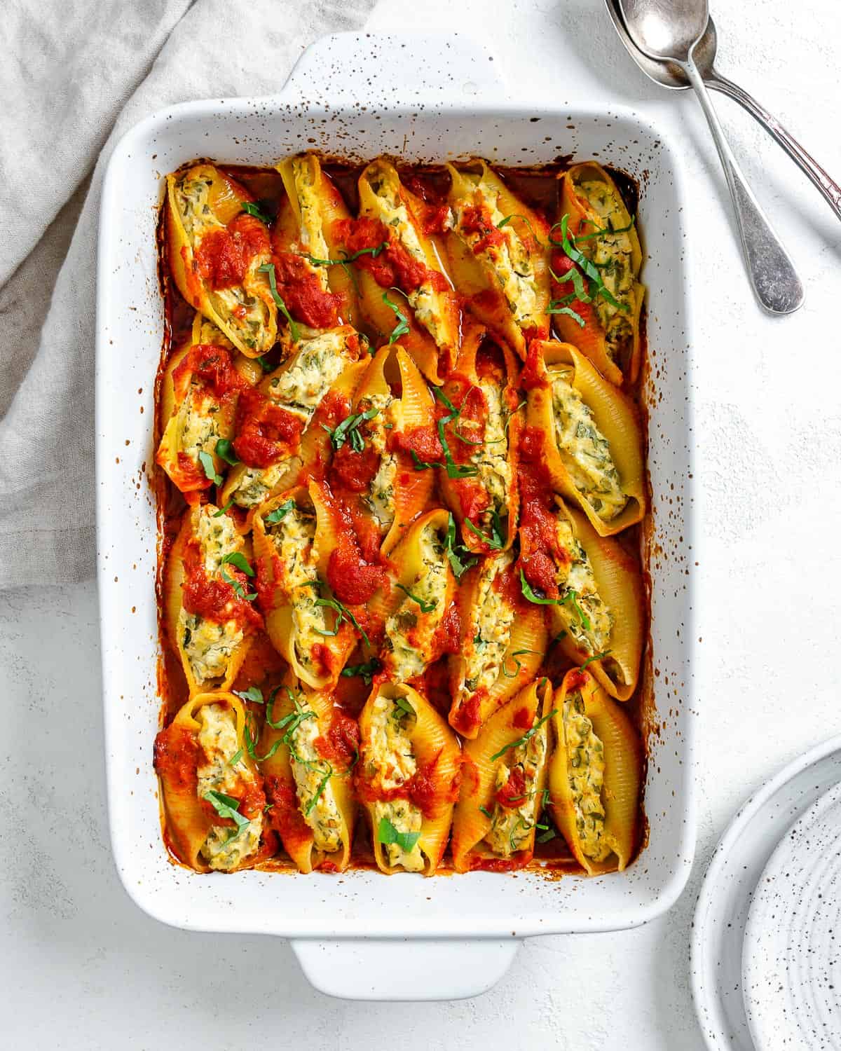 completed Stuffed Shells in a white baking dish against a white background