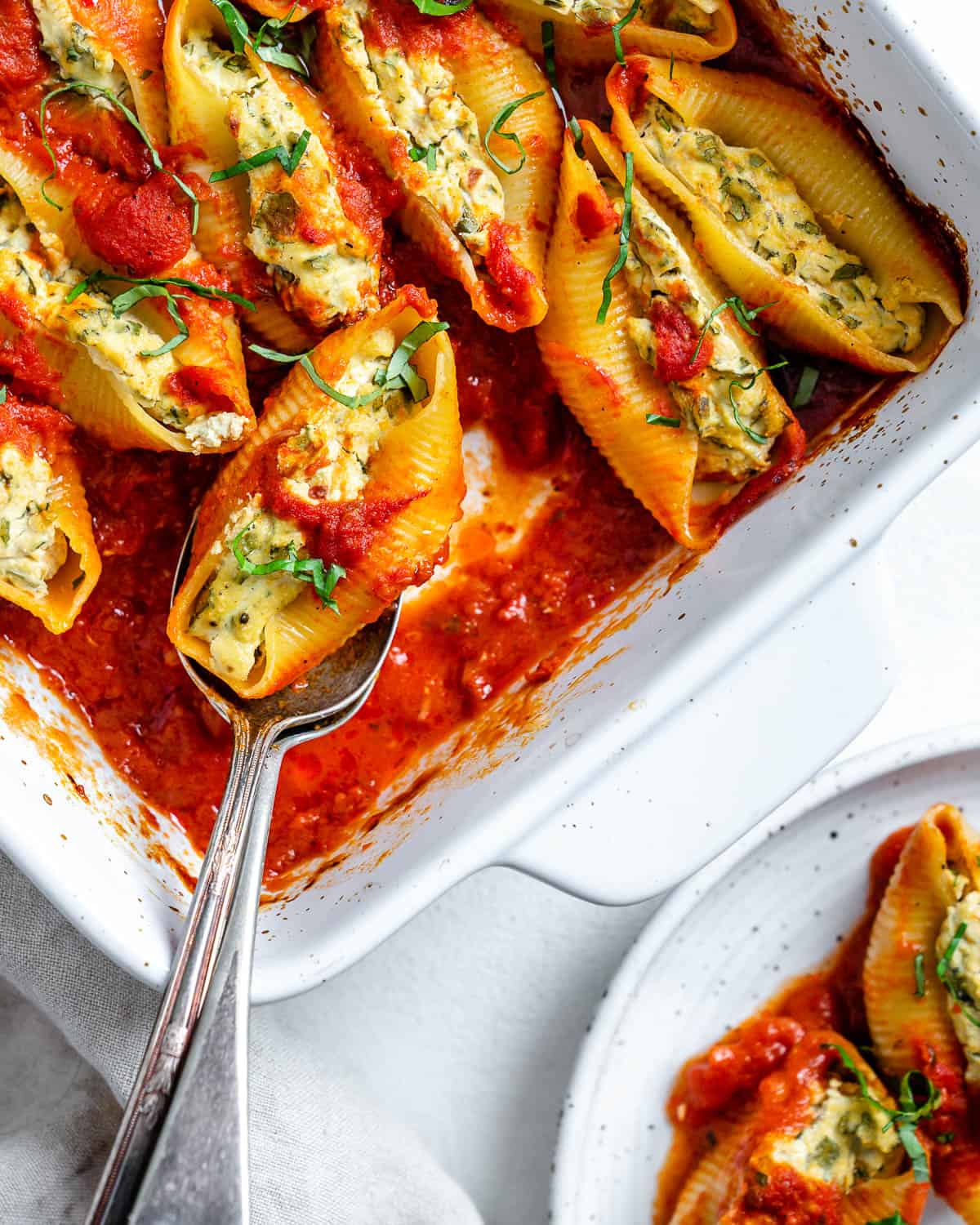 completed Stuffed Shells in a white baking dish against a white background