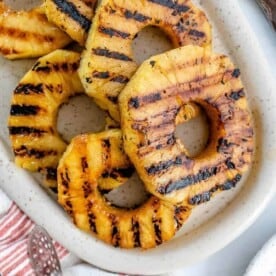 completed Grilled Pineapples spread out on a white platter against a white background