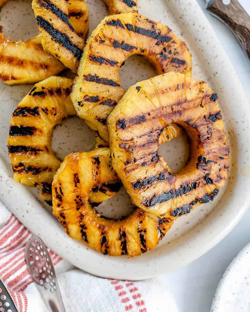 completed Grilled Pineapples spread out on a white platter against a white background