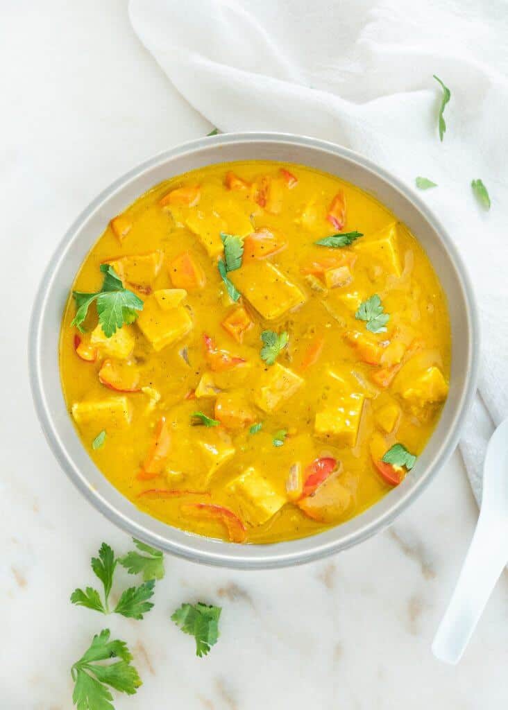 finished bowl of pumpkin curry against a white marble background