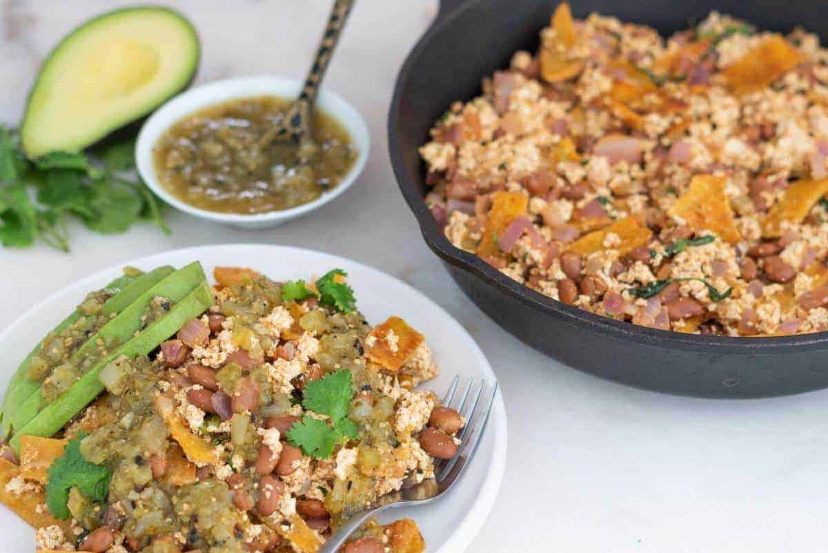 Tofu Chilaquiles on an iron skillet and served on a white dish