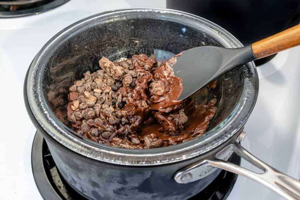 Saucepan with glass bowl and chocolate chips