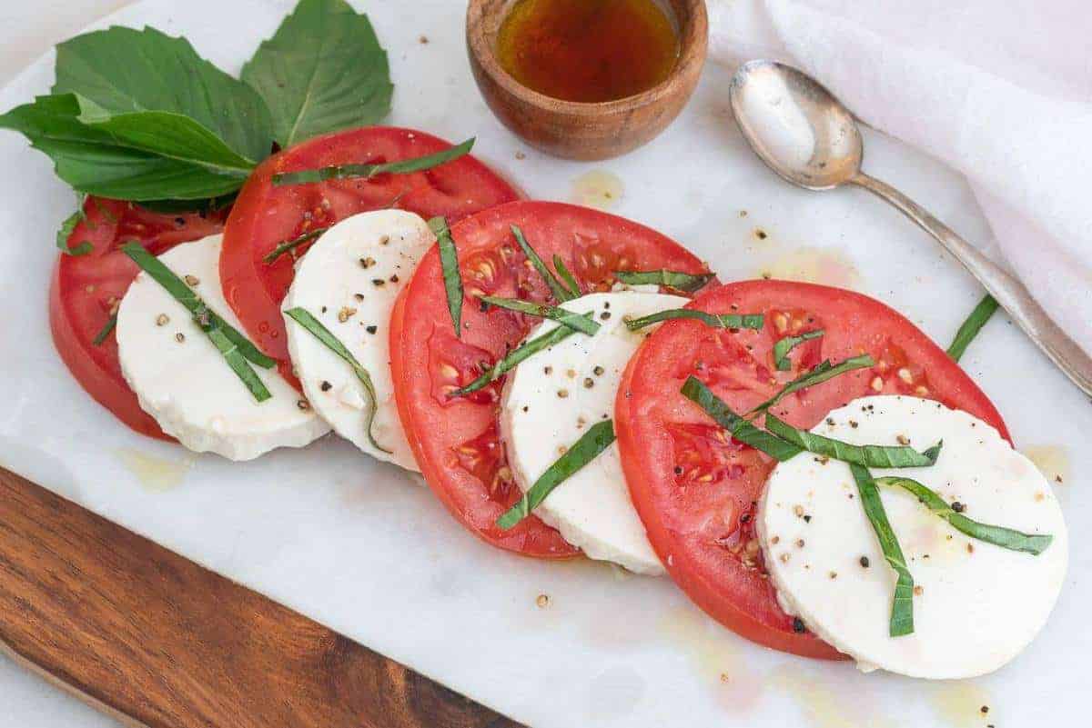 Marble Board with a Caprese salad drizzled with olive oil