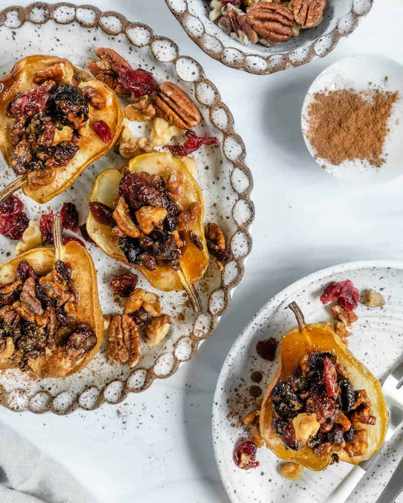 several baked pears plated with ingredients in the background