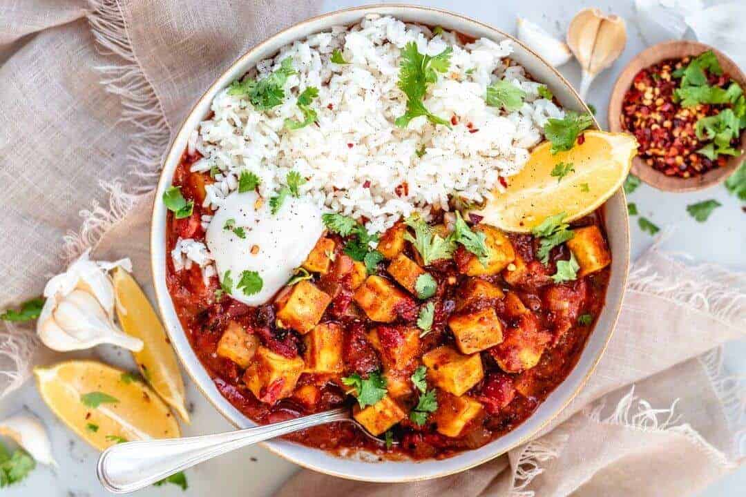 Vegan Butter Chicken served with white rice and topped with cilantro leaves