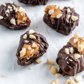 four completed peanut butter stuffed dates on a white surface