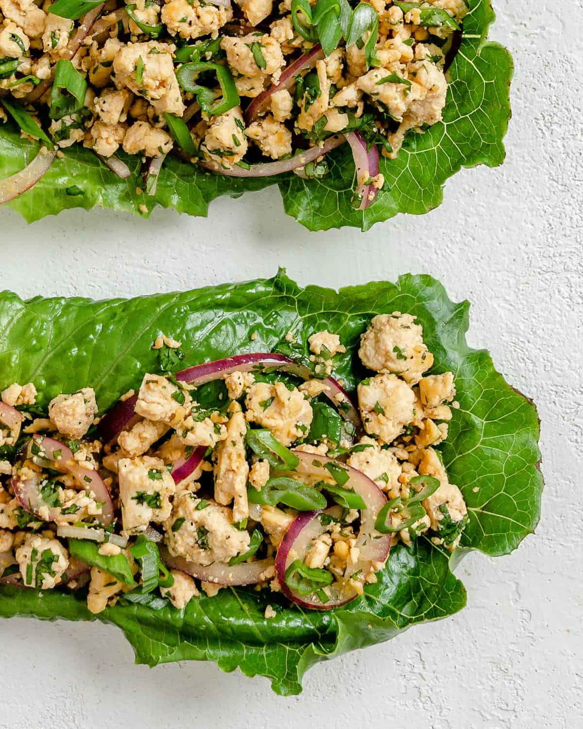 two completed larb salad pieces against a white background