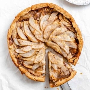 completed Easy Apple Pear Pie with a slice cut out against a white surface