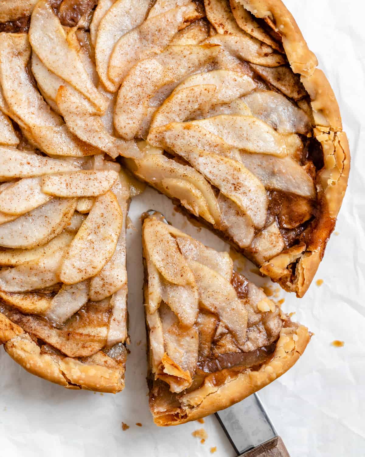 completed Easy Apple Pear Pie with a slice cut out against a white surface