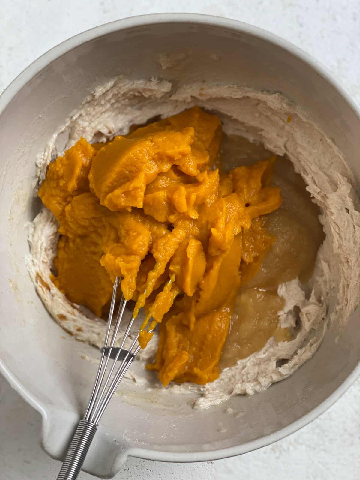 process shot of addition of pumpkin to bowl of ingredients