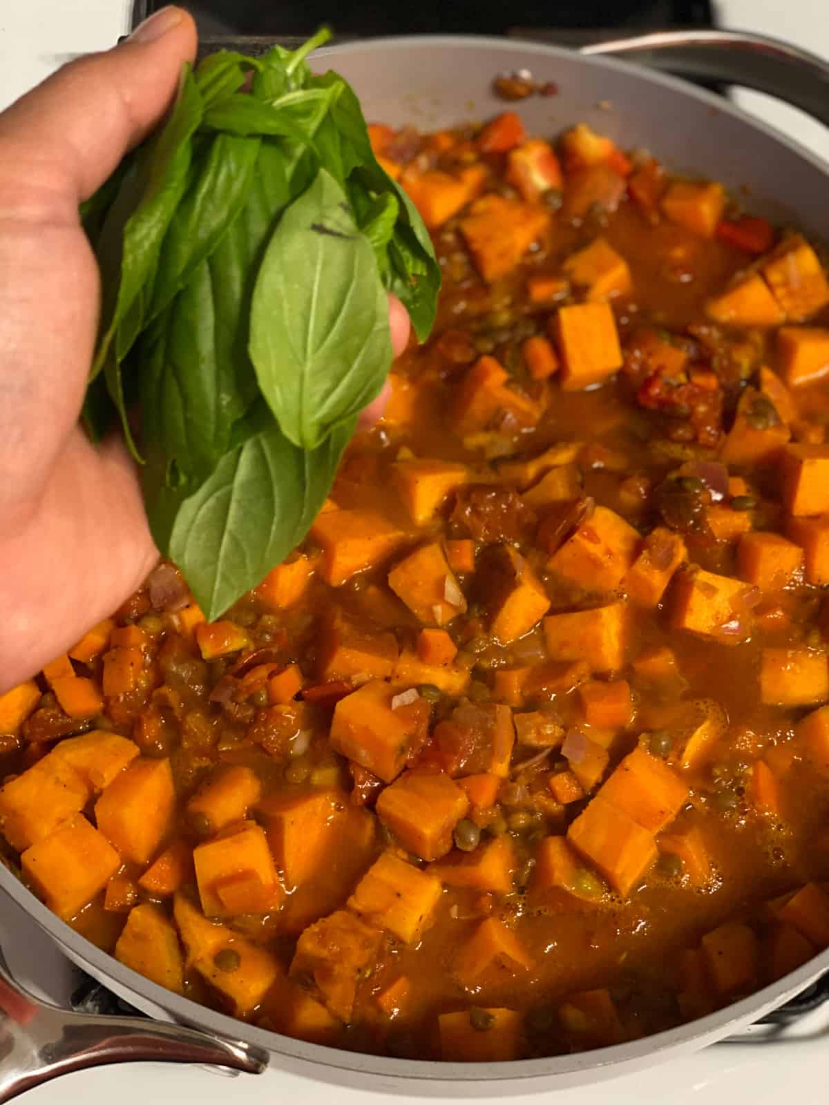 process shot of adding basil to pan