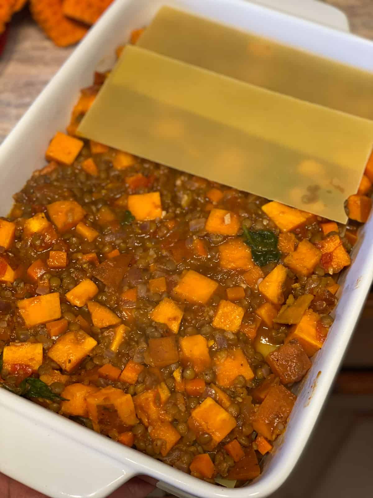 process shot of adding lasagna sheets to baking dish