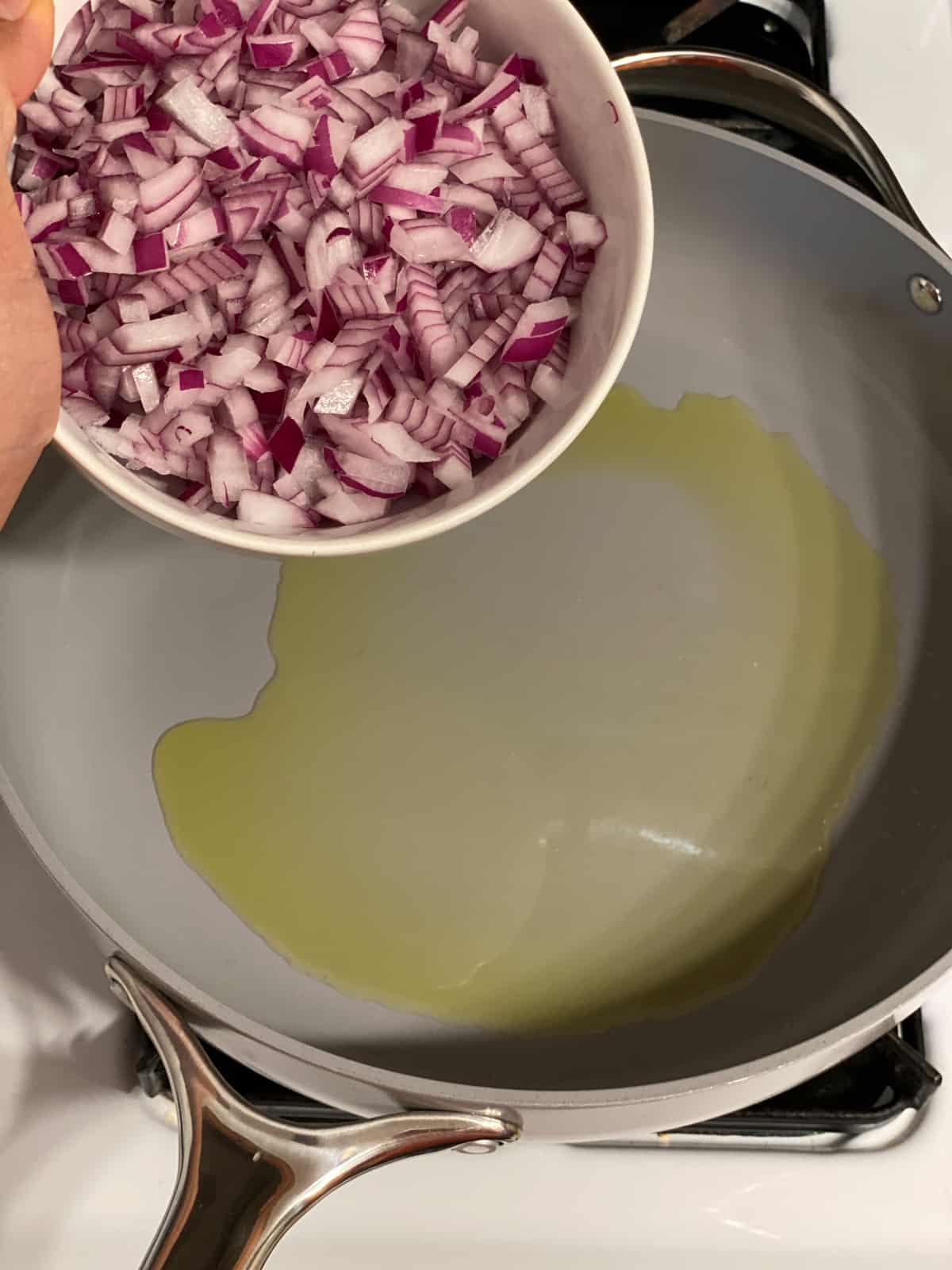 process shot of adding onions to pan