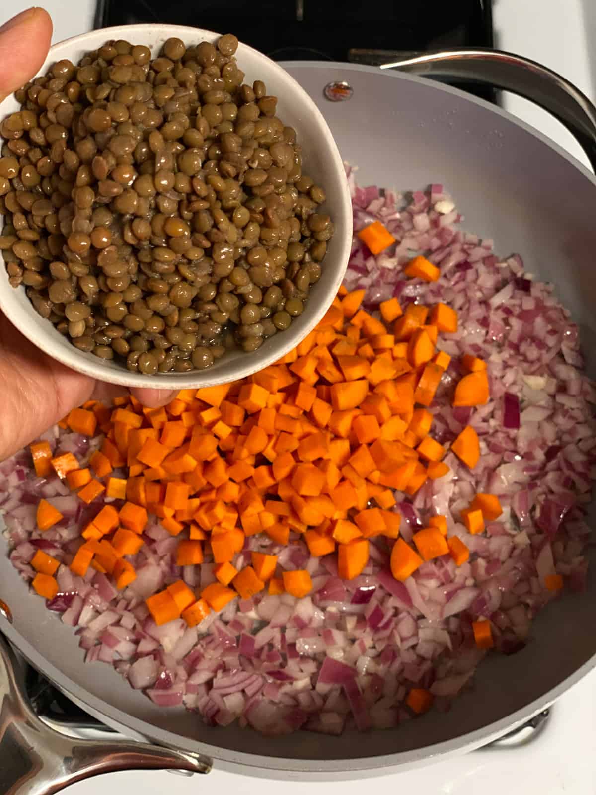 process shot of adding lentils to pan